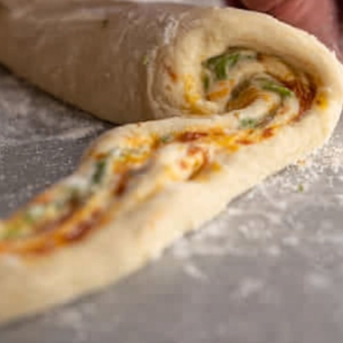 The first image shows the dough being rolled with cheese and ingredients inside. It's likely a step for creating stuffed rolls or croissants.