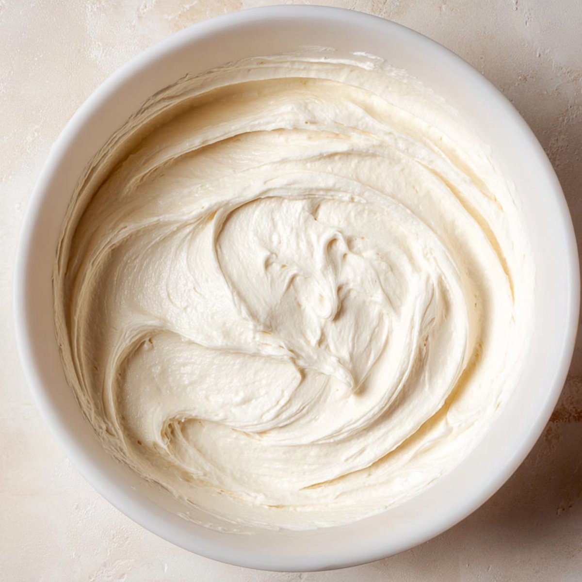 A smooth, creamy whipped mixture in a white bowl, showcasing a light and fluffy texture.